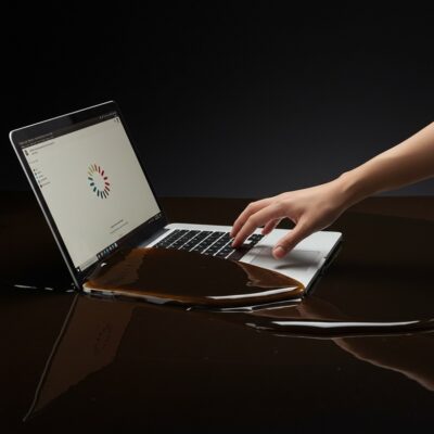 끈적한 당밀에 반쯤 잠겨 느려진 노트북과 이를 사용하려는 사용자의 손